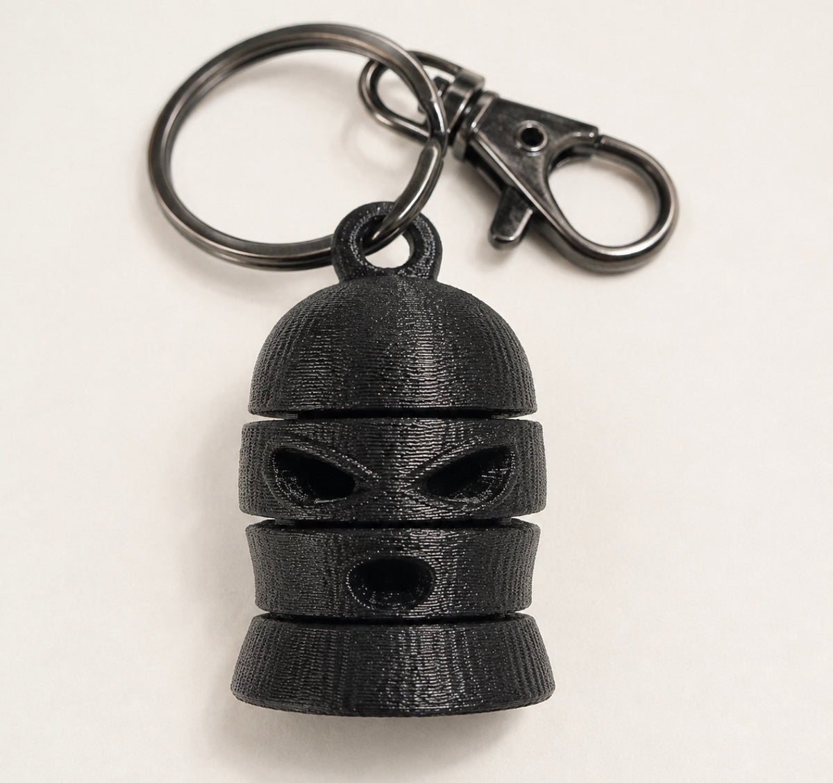 Black articulated ski mask keychain with split ring and swivel clasp